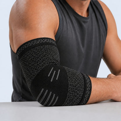 Person wearing a black elbow brace on a plain background