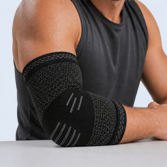 Person wearing a black elbow brace on a plain background