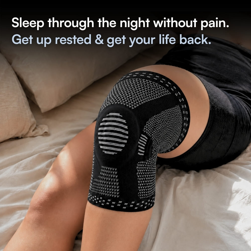 A person lying on a bed wearing a black knee compression sleeve with gray knit panels and text at the top that reads, 'Sleep through the night without pain. Get up rested & get your life back.