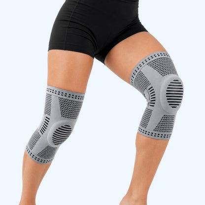 Gray knee sleeve on a person's legs against a light gray background